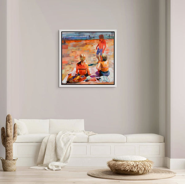 Framed original painting of people enjoying on a beach in a living room setting.